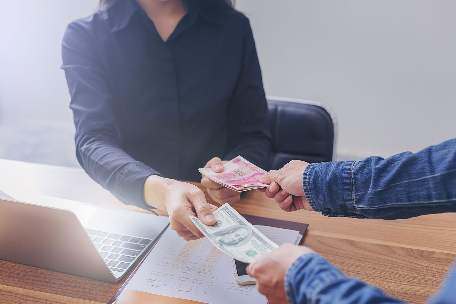 Two individuals exchanging currency - Moneyroyalexchange