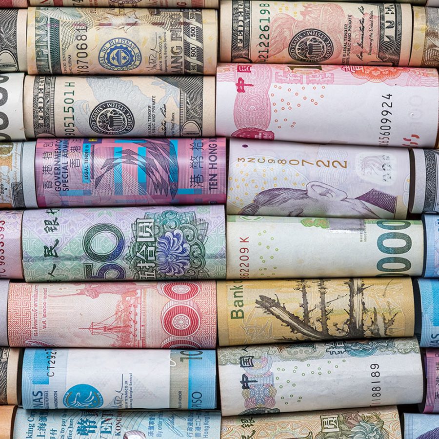 A mosaic of rolled-up banknotes from various countries showcasing the diversity of currency designs around the world.