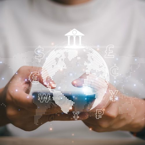 A person holding a digital representation of the globe with various financial and currency symbols,